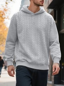 Détail de la maille torsadée grise épaisse sur un sweat à capuche chaud pour hommes