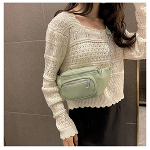 Détail du sac de poitrine en cuir PU vert clair avec zips argentés et bandoulière chaîne
