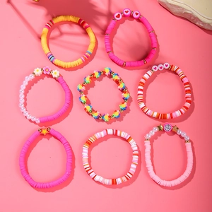 Detail of colorful polymer clay bead bracelets with floral and heart charms in a set