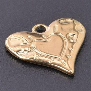 Detailed macro view of gold heart pendant with textured finish and DIY link for necklaces
