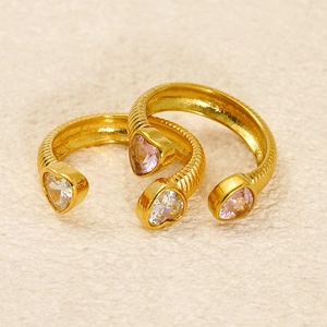 Detail von goldenen offenen Ringen mit herzförmigen rosa und klaren Zirkoniasteinen