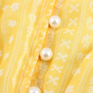 French vintage floral yellow dress showing pearl button detail and soft fabric texture