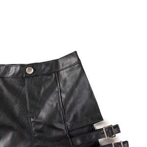 Dettaglio degli shorts in ecopelle nera con bottoni argentati e fibbia laterale