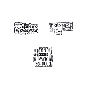 Three minimalist medical enamel pins including Doctor in Progress and Nursing School designs