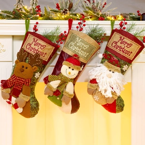 Three festive Christmas stockings with elk, snowman, and Santa hung on a warm fireplace