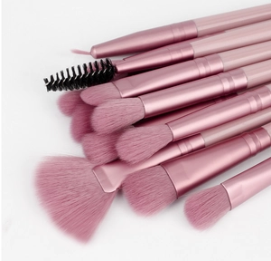 Macro shot of 12-piece pink eye makeup brushes with rose gold ferrules and soft bristles