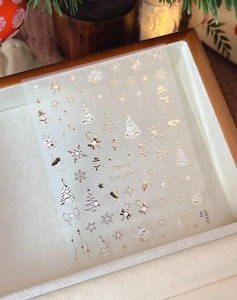 Detail shot of gold and silver Christmas nail stickers with snowflakes and bows