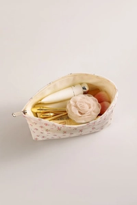 Détail d'une trousse à maquillage fleurie avec fermeture éclair et rangement interne