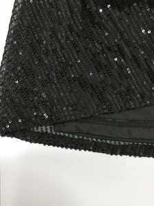 Dettaglio di fitte paillettes nere su tessuto mesh che mostra trama e cuciture dell'abito