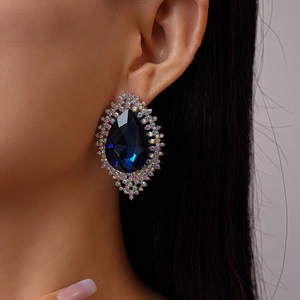 Close-up of luxury water-drop blue gem earrings with sparkling rhinestones on model