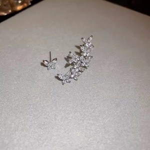 Detail of asymmetric S925 silver butterfly earrings with sparkling crystal stones