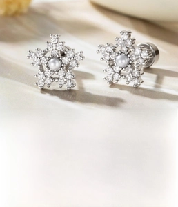 Macro shot of silver snowflake cartilage stud with micro-pave zircons and pearl center