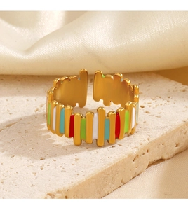 Macro shot of colorful enamel stripes on a gold-plated open ring on stone base