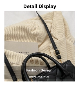Detail of black quilted shoulder bag with gold metal buckle and adjustable strap