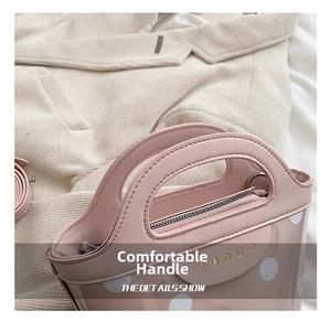 Close-up of pink polka dot bucket bag with gold zipper and smooth leather handle