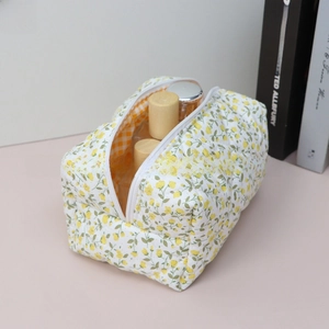 Detailed macro view of quilted floral cosmetic bag with orange checkered lining and zipper