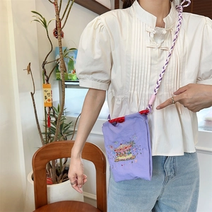 Detail of purple canvas mini bag with carousel embroidery and woven rope shoulder strap
