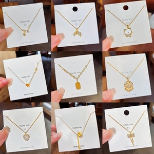 Detail of assorted gold heart and butterfly pendant necklaces on white display cards
