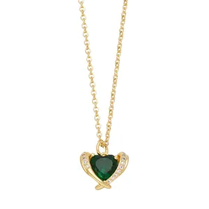 Minimalist gold heart necklace with green gemstone pendant on thin chain over white background