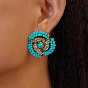 Detailed macro view of vintage gold flower earring with turquoise beads and crystals