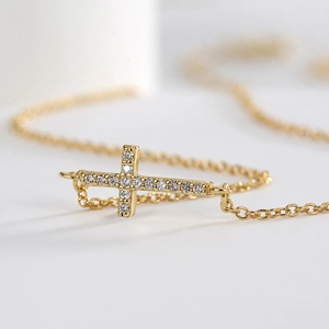 Elegant gold-plated sideways cross necklace with sparkling cubic zirconia pavé stones