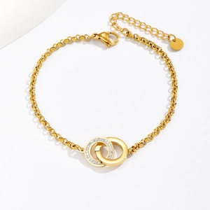 Detailed macro view of interlocking gold circles with pave crystals on a rolo chain bracelet