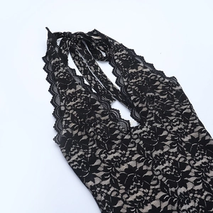 Détail du tissu en dentelle florale noire sur une robe dos nu avec broderies fines