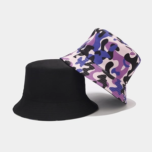 Detail of reversible bucket hat showing solid black and purple camouflage cotton fabric