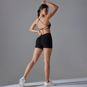 Detail of cross-back sports bra and high-waisted peach lift yoga shorts in black