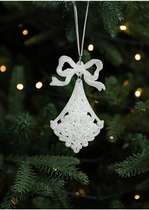 Close-up of a white glitter Christmas bell ornament with a bow on a festive tree branch