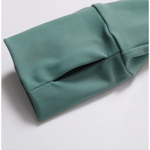 Détail de la manche de veste de yoga sarcelle avec poignet côtelé et passe-pouce