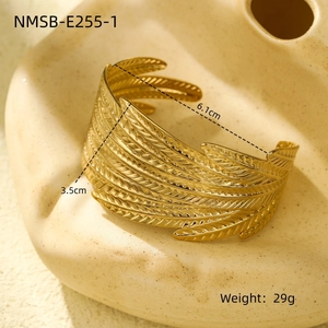 Detailed view of golden feather-textured steel cuff bracelet with dimensions and weight