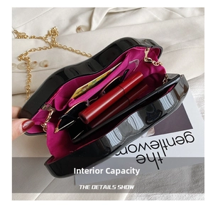 Internal view of black patent leather lip-shaped bag with pink lining and gold chain