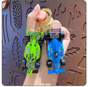 Close-up of mini F1 racing car keychains in green and blue with gold metal rings