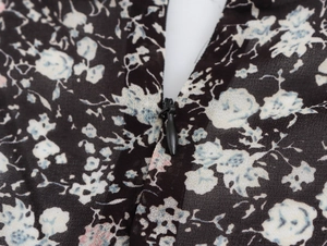 Close-up of invisible zipper and floral chiffon fabric on elegant V-neck dress
