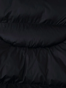 Macro shot of black puffy winter jacket showing smooth fabric texture and stitching