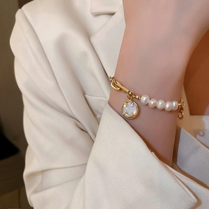 Elegant freshwater pearl bracelet with gold chain and sparkling smile pendant on wrist