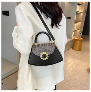 Detailansicht der Handtasche mit Krokodilmuster und goldener Sonnenblumen-Metallschnalle