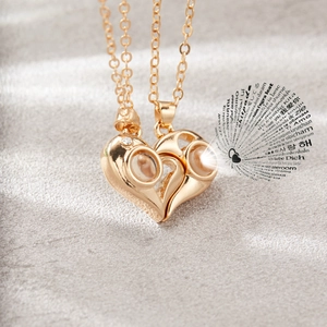 Close-up of heart-shaped magnetic couple necklace with 100 languages I love you projection