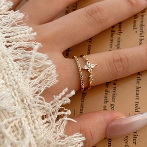 Exquisite gold double-layer star ring set with pavé cubic zirconia on an open book
