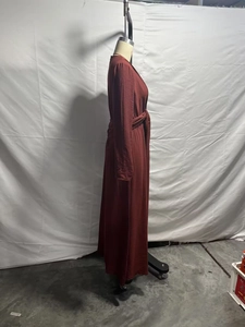 Detailed view of the burgundy long sleeve dress featuring waist tie and textured fabric