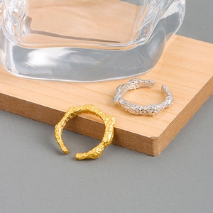 Anelli aperti con texture lava irregolare in oro e argento dal design minimalista