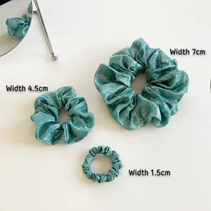 Metallic blue silk scrunchie set in three sizes with elegant pleated texture