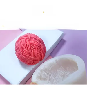 Detailed view of knitting yarn ball silicone mold with pink textured candle result