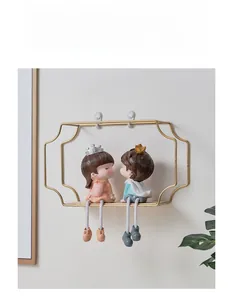 Detail of gold metal wall shelf with wooden base and romantic couple figurines