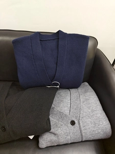 Folded knit cardigans in navy, gray, and black colors showing soft textured fabric