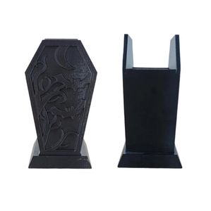 Macro shot of gothic coffin makeup brush holder with bat and plant textures