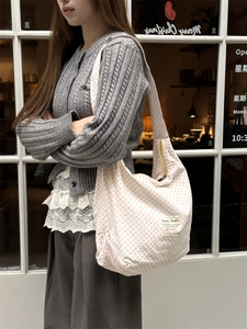 Detailed view of the pink polka dot pattern and sturdy zipper on the white canvas tote