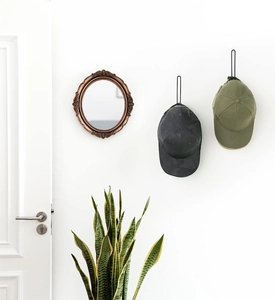 Wall-mounted black metal L-shaped baseball cap hooks showing organizer on white wall