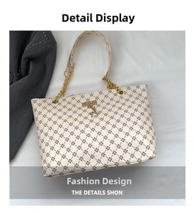 Dettaglio borsa shopper con motivo geometrico, catena dorata e fibbia a forma di cervo
